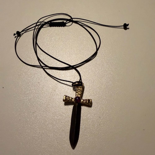 Sword-shaped pendant like new with red stone and leather cord