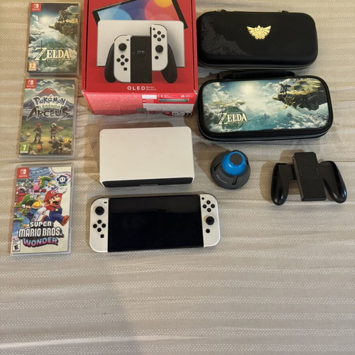 Nintendo Switch OLED console used with 3 games and Zelda cases