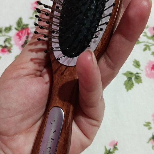 Small hairbrush with metal pins and rubber cushion