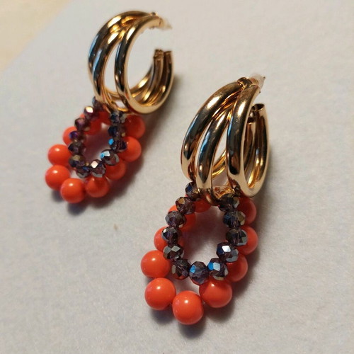 Handmade earrings with orange and purple beads on gold triple hoops