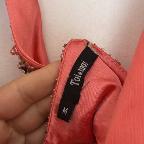Coral short evening dress with crisscross straps, V neckline, and shiny embroidered beads