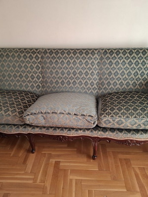 Vintage three-seater sofa and two antique armchairs with dark wood frame