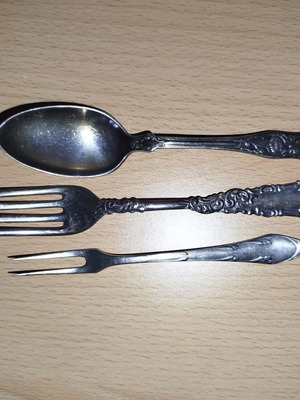 Vintage silver-plated cutlery set with knife, spoon, fork, and dessert fork