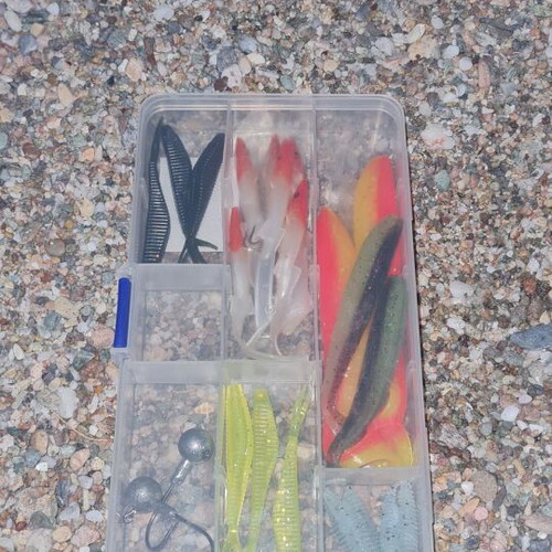 Box with used silicone worms and fish lures