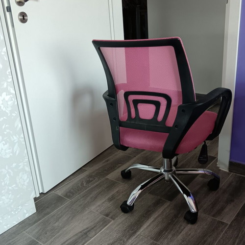 Office chair with armrests used, pink mesh fabric