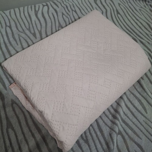 Quilted bed cover in soft pink