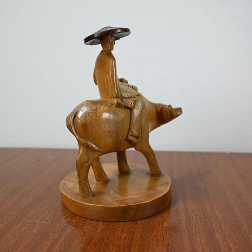 Vintage wooden carving of a man on a buffalo used