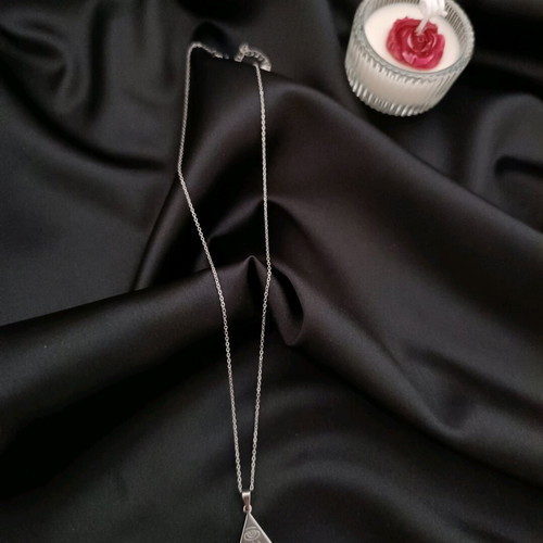 Minimal handmade steel chain necklace with a triangle pendant featuring a carved eye