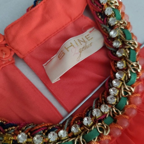 Coral dress with a jewel tie at the neck