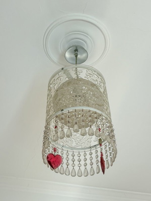 Retro ceiling light with transparent and red hanging decorations, used