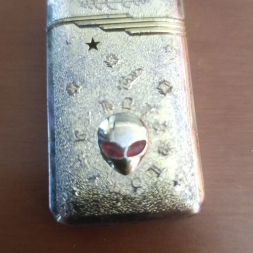 Collectible metal lighter used with zodiac symbols and alien motif