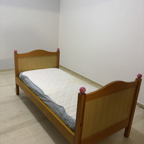 Single wooden bed with mattress, natural wood finish, pink details