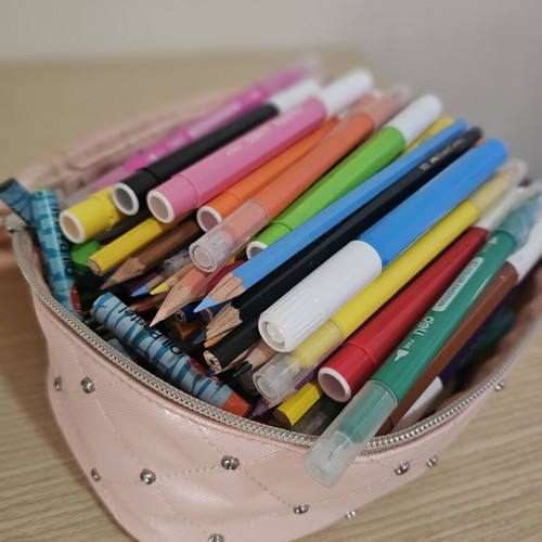 Makeup bag with markers, colored pencils, crayons, and watercolors used
