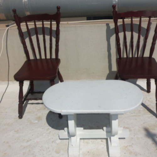 Wooden set with oval white table and 2 traditional dark chairs used for outdoor