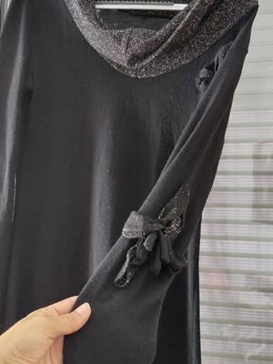 Women's black knitted winter dress with silver details and flower