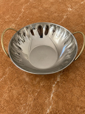 Metal serving bowl with gold handles
