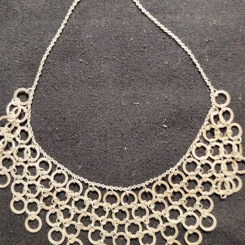 Necklace with multiple rows of interconnected silver rings like new