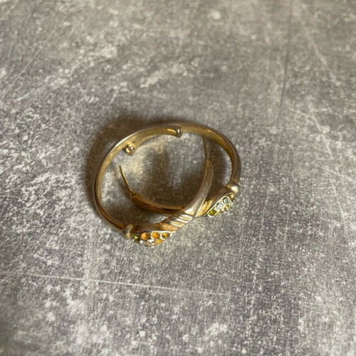 Gold-colored earrings used with small diamonds, some missing
