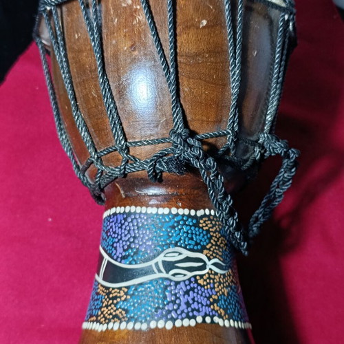 Djembe drum used with hand-painted snake design and torn skin