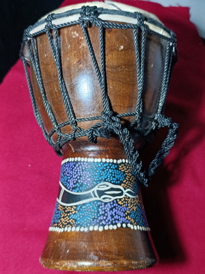Djembe drum used with hand-painted snake design and torn skin