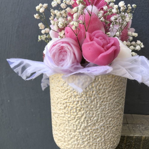Flower arrangement with scented candles in plaster vase