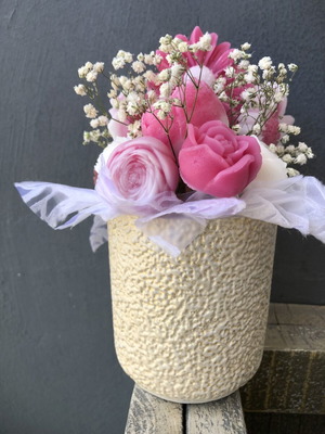 Flower arrangement with scented candles in plaster vase
