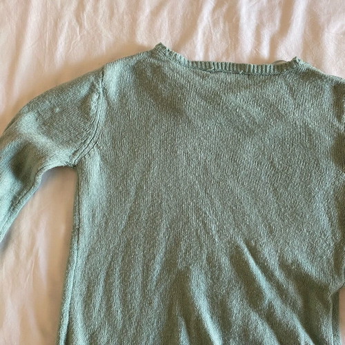 Thin turquoise sweater used with neckline details