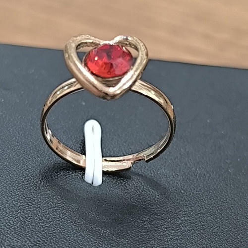Gold-colored ring with heart and red stone, new