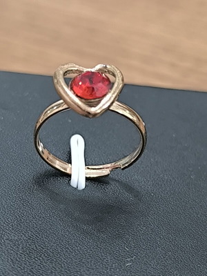 Gold-colored ring with heart and red stone, new