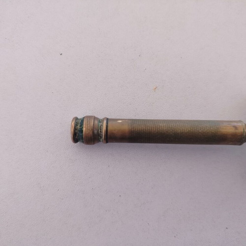 Vintage brass razor used with visible wear and oxidation
