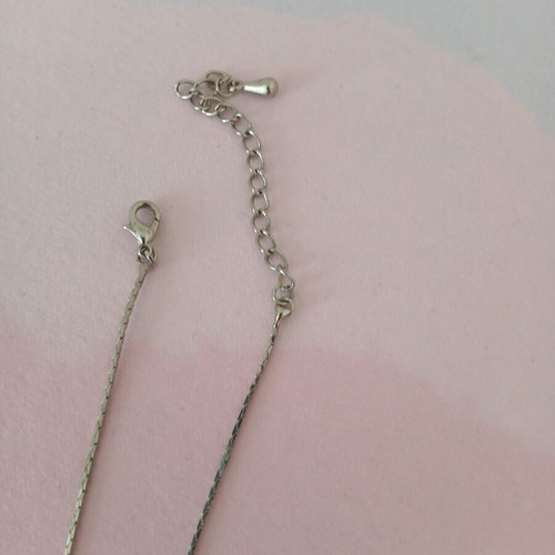 Silver necklace used with white stones and yellowish square
