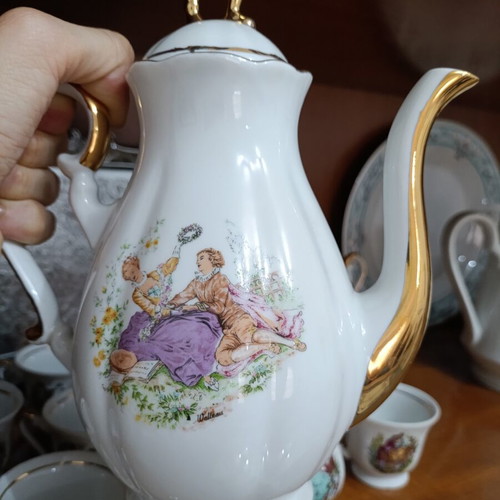 Vintage porcelain coffee and tea set with gold details and romantic scenes