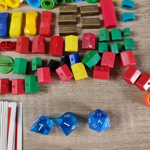 Lot of used board game parts including pawns, dice, cards, and hourglasses