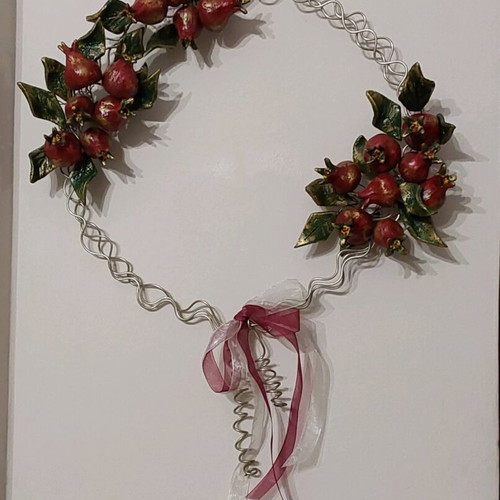 Handmade metal and clay wreath with pomegranates