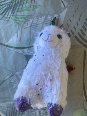 Unicorn plush toy with colorful shiny wings and metallic purple details
