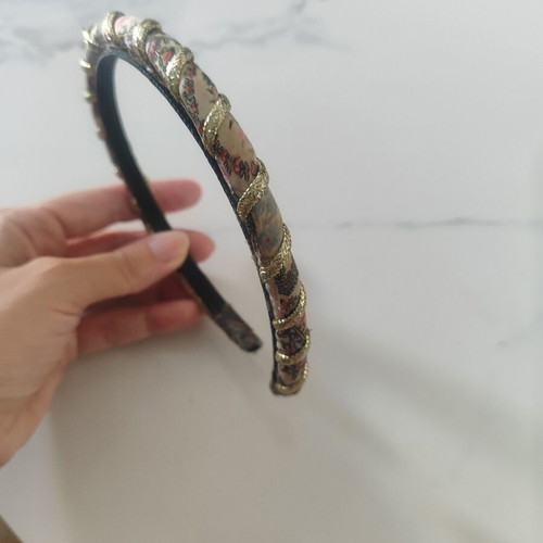 Headband with fabric floral design and gold braid used, abo