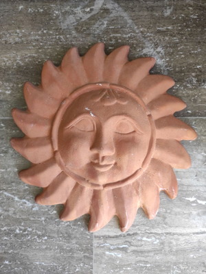 Clay wall decorative depicting the Sun in human form
