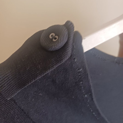 Black dress with shoulder buttons and distinctive sleeves