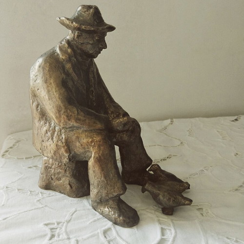 Realistic sculpture of an elderly man feeding pigeons, new