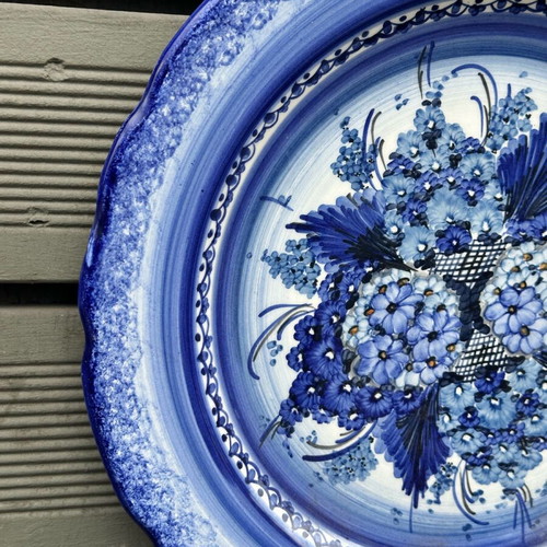 Handmade ceramic wall plate used with blue floral motif