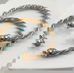 Βραχιόλι-cuff ατσάλινο με ανάγλυφη στριφτή βάση σε χρυσό ή ασημί χρώμα και δύο πέτρες χαολίτη στις άκρες του.