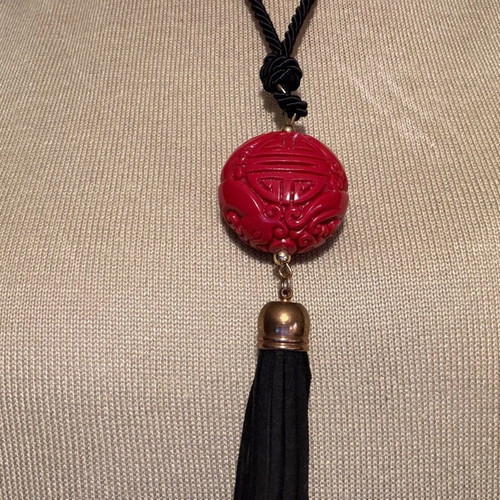 Long pendant like new with red carved bead and black fabric cord