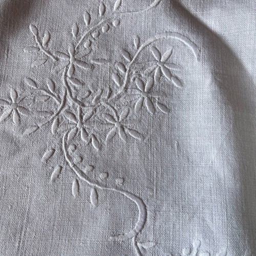 White embroidered tablecloth used on linen fabric with lace