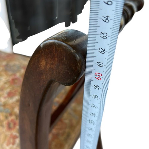 Wooden stool with carved high arms