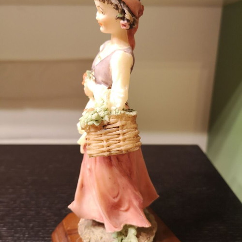 Porcelain figure used with wooden base and girl carrying flowers
