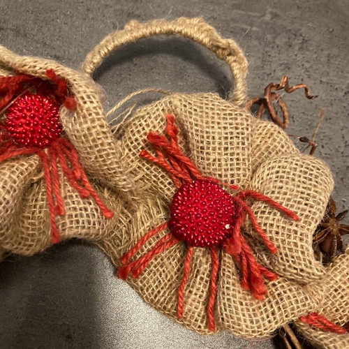 Christmas wreath made of natural materials with knitted handle