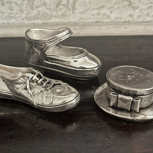 Set of three decorative stainless steel items: baby shoe, sports shoe, hat with bow