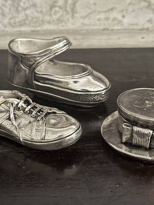 Set of three decorative stainless steel items: baby shoe, sports shoe, hat with bow