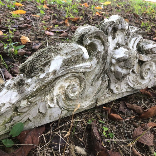 Old plaster pediment used with spiral motifs and human head