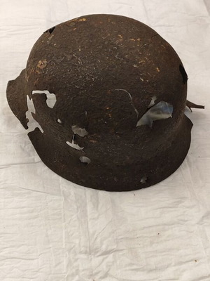 German helmet World War II used, relic with battle damage